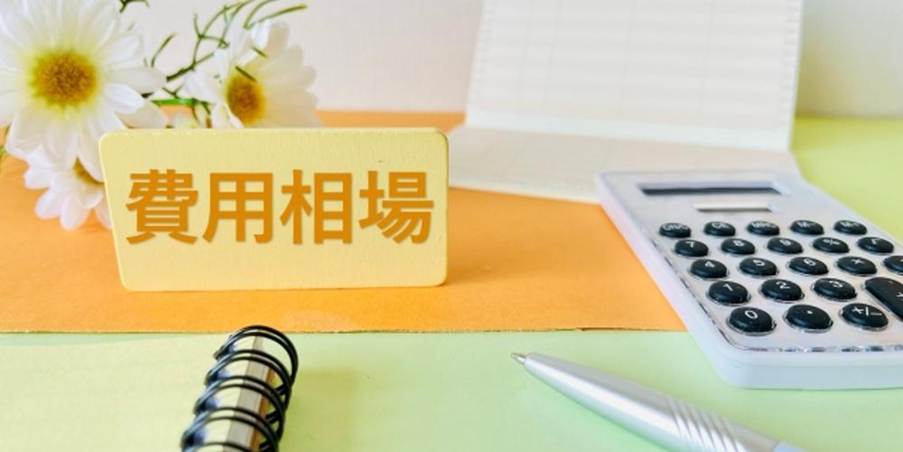 費用相談のイメージ：電卓、通帳、ノートとペンが並ぶオフィスのデスク
