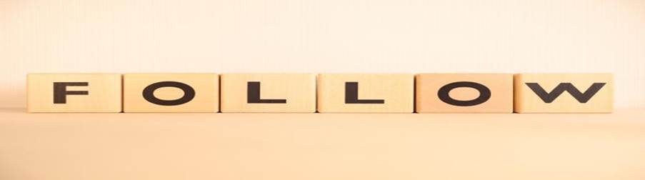 木製ブロックに並んだ『FOLLOW』の文字：フォローアップや支援体制のイメー
