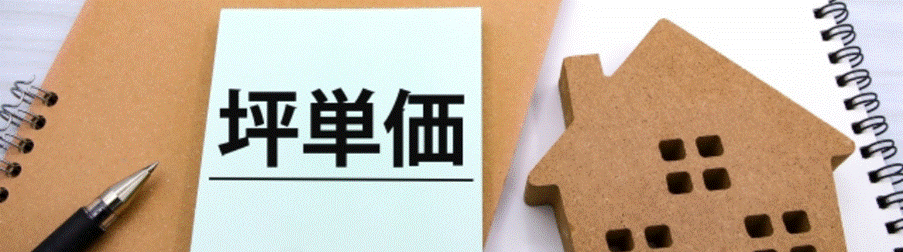 ノートと木製の家のオブジェの横に「坪単価」と書かれたメモが置かれているイメージ