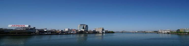 都市の川辺と高層ビル群：地域経済や都市インフラの発展を象徴する風景