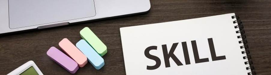 ノートに書かれた『SKILL』の文字とパソコン、文具、電卓
