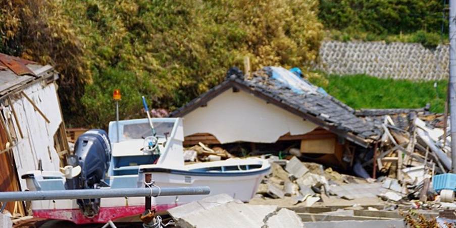 地震被害を受けた家屋と船の残骸(津波や地震による被災地の状況)