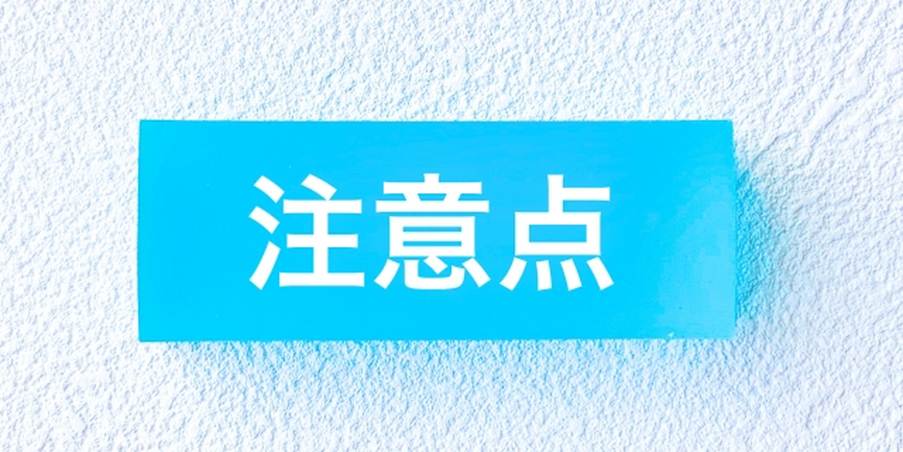 青い壁に掲示された「注意点」の文字が描かれたプレートのイメージ