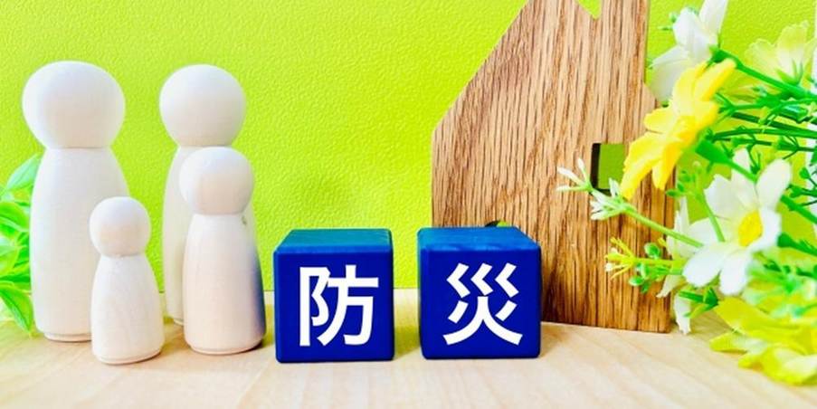 防災をテーマにした木製の家と家族のフィギュア(家庭での防災意識を示すイメージ)