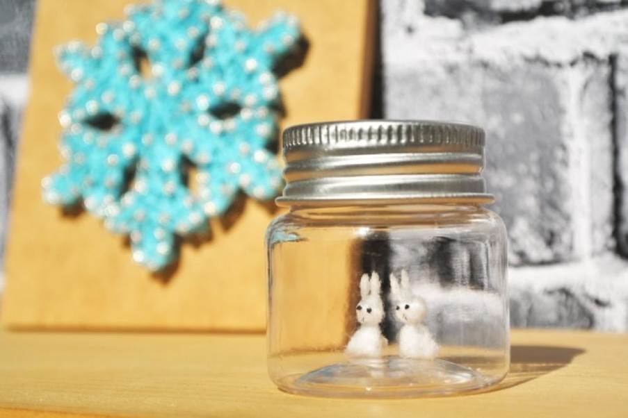 雪の結晶の飾りと小瓶の中の白いうさぎ、冬の季節感を演出した装飾イメージ