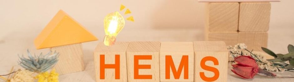 「HEMS」と書かれたブロックと家の形をした積み木、電球アイコンが並ぶ省エネ住宅のイメージ